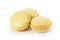 Three yellow lemon macarons isolated on white