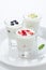 Three yogurt with fruit in a glass beaker vertical closeup