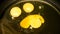 Three yolks from eggs in a frying pan in oil