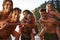 Three young adult couples piggy backing in a lake, close up