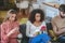 Three young adult friends watching with their smartphones on sofa