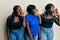 Three young african american friends wearing casual clothes shouting and screaming loud to side with hand on mouth