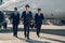 Three young aviators walking across the aerodrome