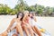 Three young beautiful girlfriends relax and have fun on a tropical beach, travel and vacation concept