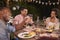 Three young black adults enjoying a garden dinner party