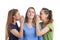 Three Young Caucasian Girlfriends Sharing Their Secrets Whispering to Ears.Isolated Over White Background