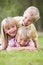 Three young children playing outdoors smiling