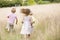 Three young children running outdoors