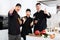 Three young cooks wearing black uniform showing thumbs up