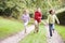 Three young friends running on a path outdoors