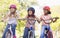 Three young girl friends on bicycles smiling