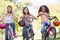 Three young girl friends on bicycles smiling