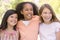 Three young girl friends outdoors smiling