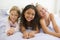 Three Young Girls Lying On A Bed In Their Pajamas