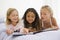 Three Young Girls Lying On A Bed In Their Pajamas