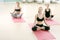 Three young girls meditate in sports gym