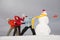 Three young girls pull snowman by scarf