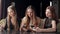 Three young girls sitting in a cafe with phones in hand, the phone addiction.