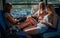 Three young girls in sunset lighting traveling in train car and their reflections in window