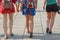 Three young girls walk along street. Young tourists walking along city street