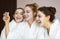 Three young happy women with face masks at spa resort. Frenship