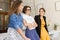 Three young joyful women leaning on desk while happily spending