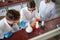 Three young laborant technicians examining chemical reactions