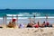 Three young ladies wearing Christmas hat on Christmas eve on Bondi beach Sydney Australia