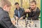 Three young men in black jackets sit in gazebo,