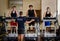 Three young men exercising on treadmills with personal trainer