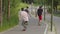 Three young men skateboarding in the green park on the smooth road