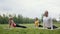 Three young models sportsmen practice yoga in the park