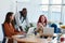 Three young multicultural employees laughing at working meeting in office