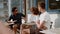 Three young people sitting at cafe and chattingli