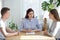 Three young people sitting at the desk in office