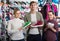 Three young persons showing an assortment of the shoes in the st