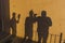 Three young photographer friend shadows on a wall with silly poses