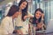 Three young woman drinking coffee have fun at cafe.