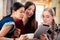 Three young women looking at pictures on tablet