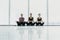 Three young women meditating in lotus pose during yoga class in health club. Young three Women sitting on floor near window with