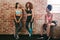 Three young women resting after exercise in gym