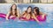 Three young women splashing in pool