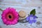 Three Zen stones on used wood with purple and pink flowers