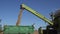 Thresher unloads wheat grain into truck trailer on farmland field. 4K