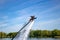 Thrillseeker, athlete strapped to Jet Lev, levitation soars into a blue sky with whispy clouds