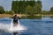 Thrillseeker, water sports lover, athlete strapped to Jet Lev, levitation hovers over lake with blue sky and trees