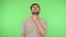 Throat pain. Unhealthy young man in shirt rubbing his neck and grimacing from pain. green background, chroma key