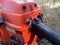 Throttle control and on/off switch on old used petrol chainsaw covered with sawdust, wood cutter tool