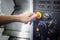 A Thumb ready to press emergency Stop button on Control panel of
