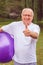 Thumb up for healthy exercising - Smiling senior man with fitness balls in park